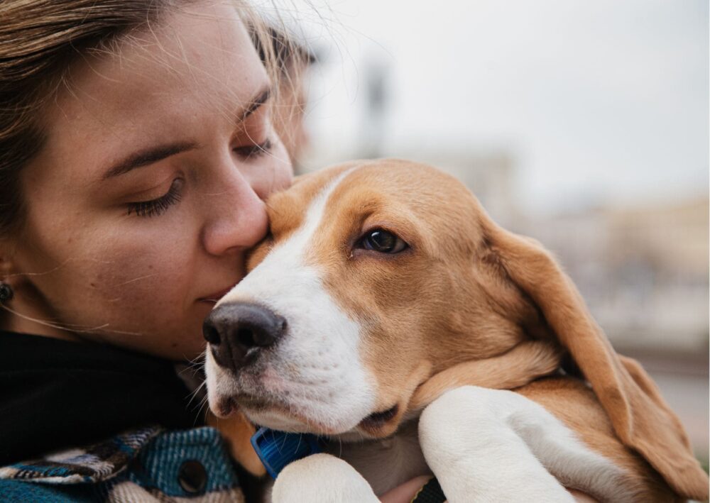 mulher beijando seu cachorro. conheca os beneficios do beijo