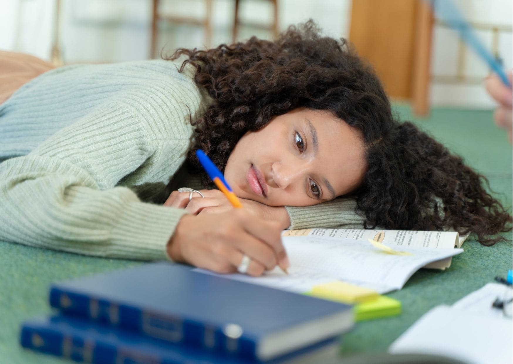 mulher deitada, com dificuldades em escrever, necessita parar a procrastinação
